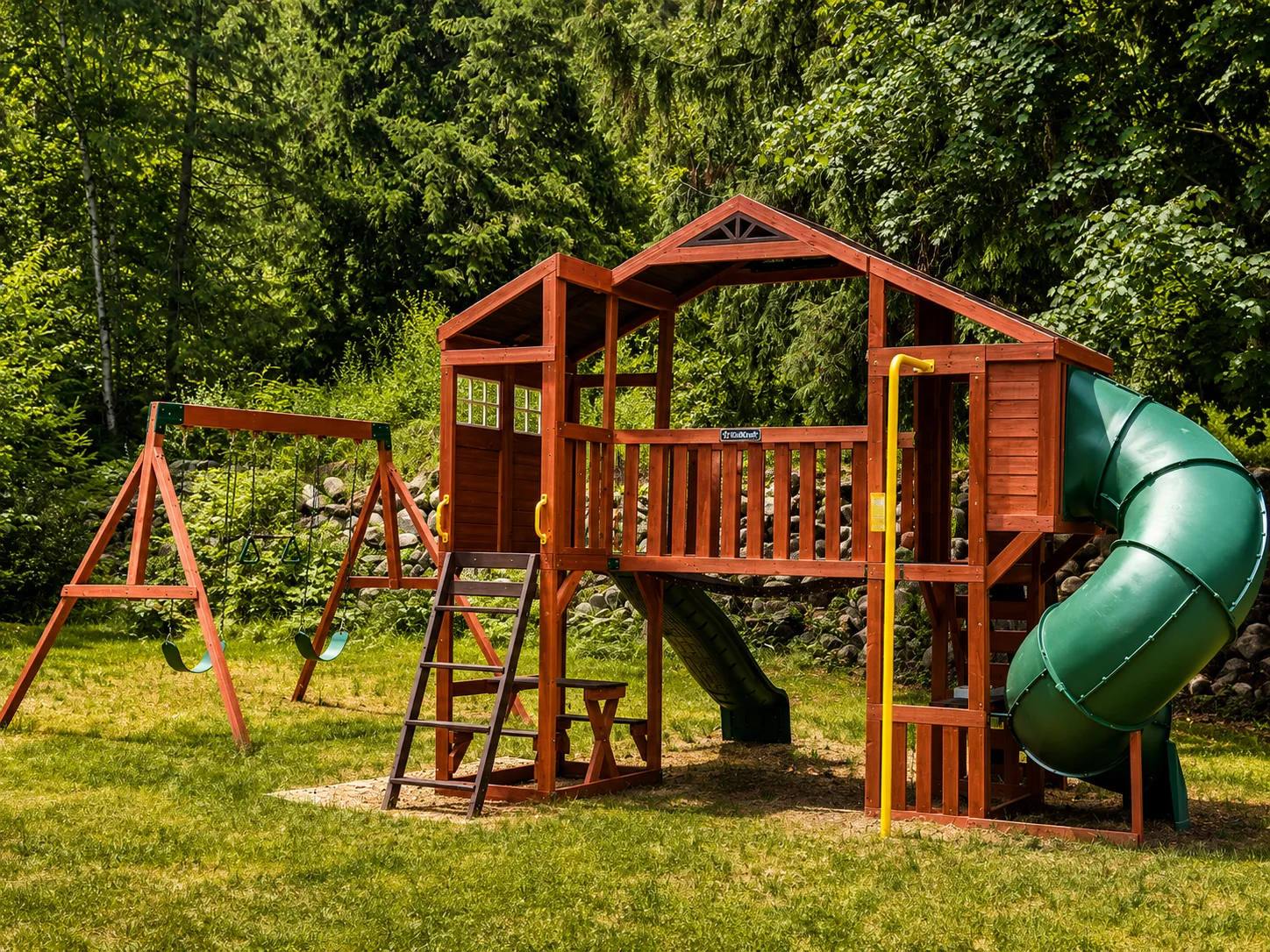 The wooden play structure with swings, slide and climbing fort